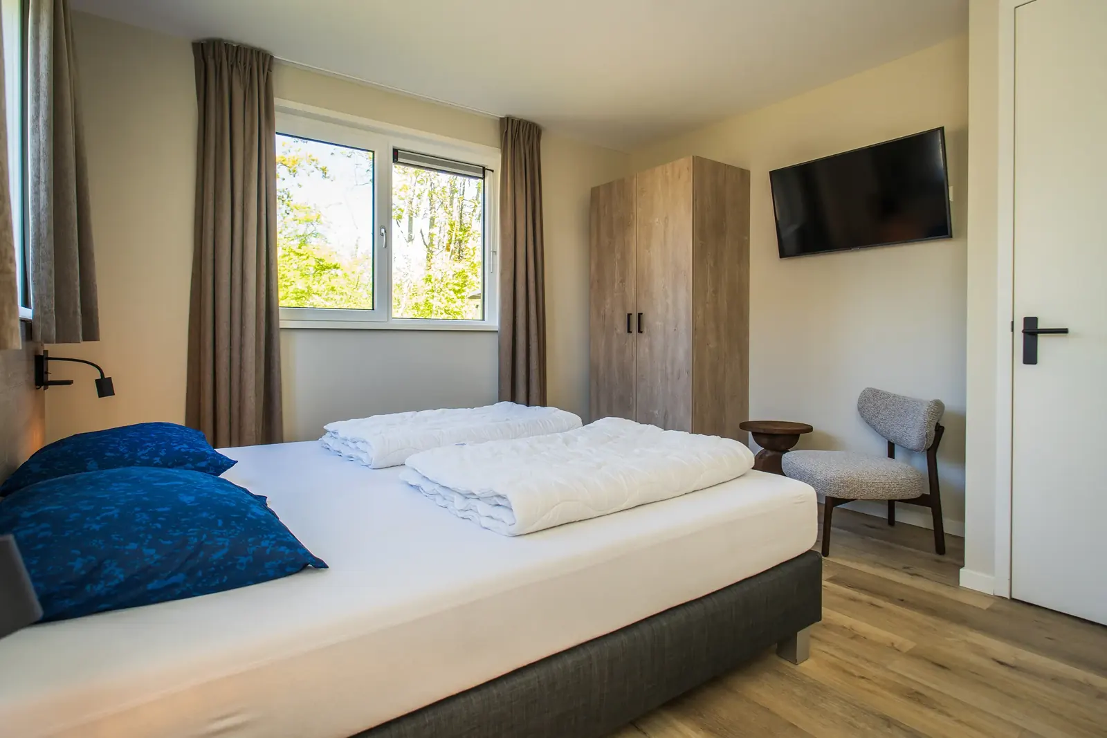 Schlafzimmer im Erdgeschoss mit Doppelbett und TV