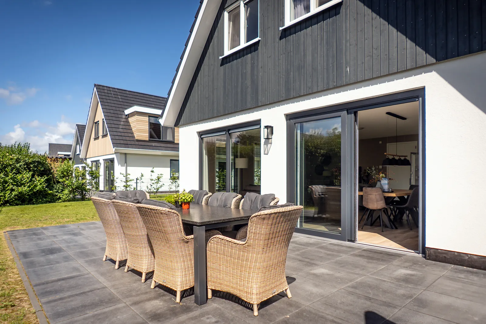 Terrasse mit Gartensitzgruppe und Schiebetür zum Wohnzimmer von Villa 21 auf Texel